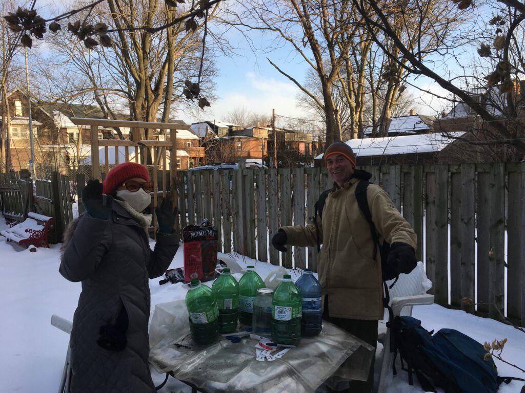 Gardeners sowing seeds in backyard jugs in the winter to transplant the following spring